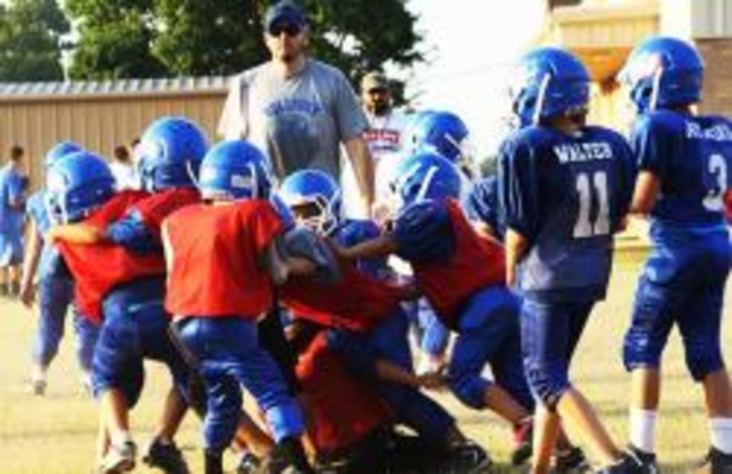 A pack of first and second grade Bulldogs show good defense during Thursday's scrimmage against the third and fourth graders.