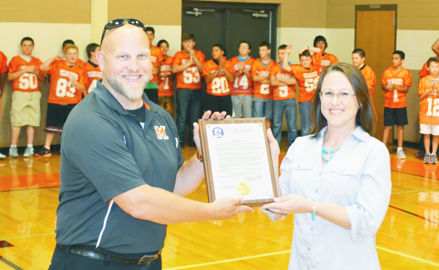 From left, Assistant Band Director-Percussion Specialist James Best accepts an official proclamation by the Mayor of Mineola from Mineola City Secretary Cynthia Karch, recognizing the middle school band and their accomplishment as UIL State Honor Band.
