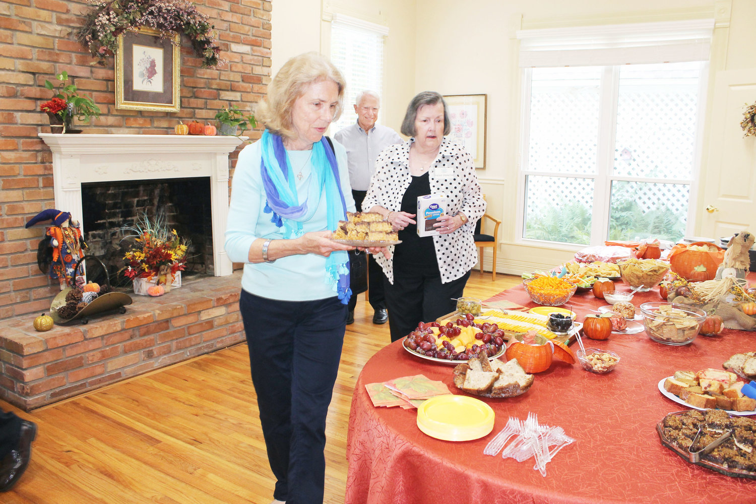 The staff and volunteers at Grace Healthcare Ministry were happy to show off renovations from the past year at Tuesday's chamber mixer open house. Marilyn Brown (wife of Grace Healthcare Board President Warren Brown seen in the background) and Helen Haneline look for room on the table for more goodies. (Monitor photo by Doris Newman)