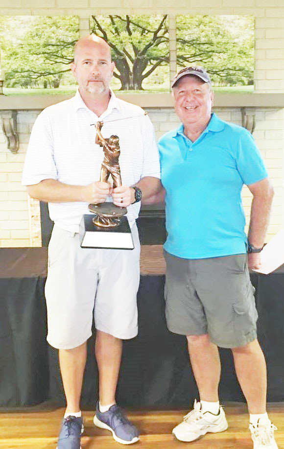 Mineola Country Club Champion Chad Hutchins clutches his Club Champion trophy with Mineola Country Club President Tommy Hobson.
