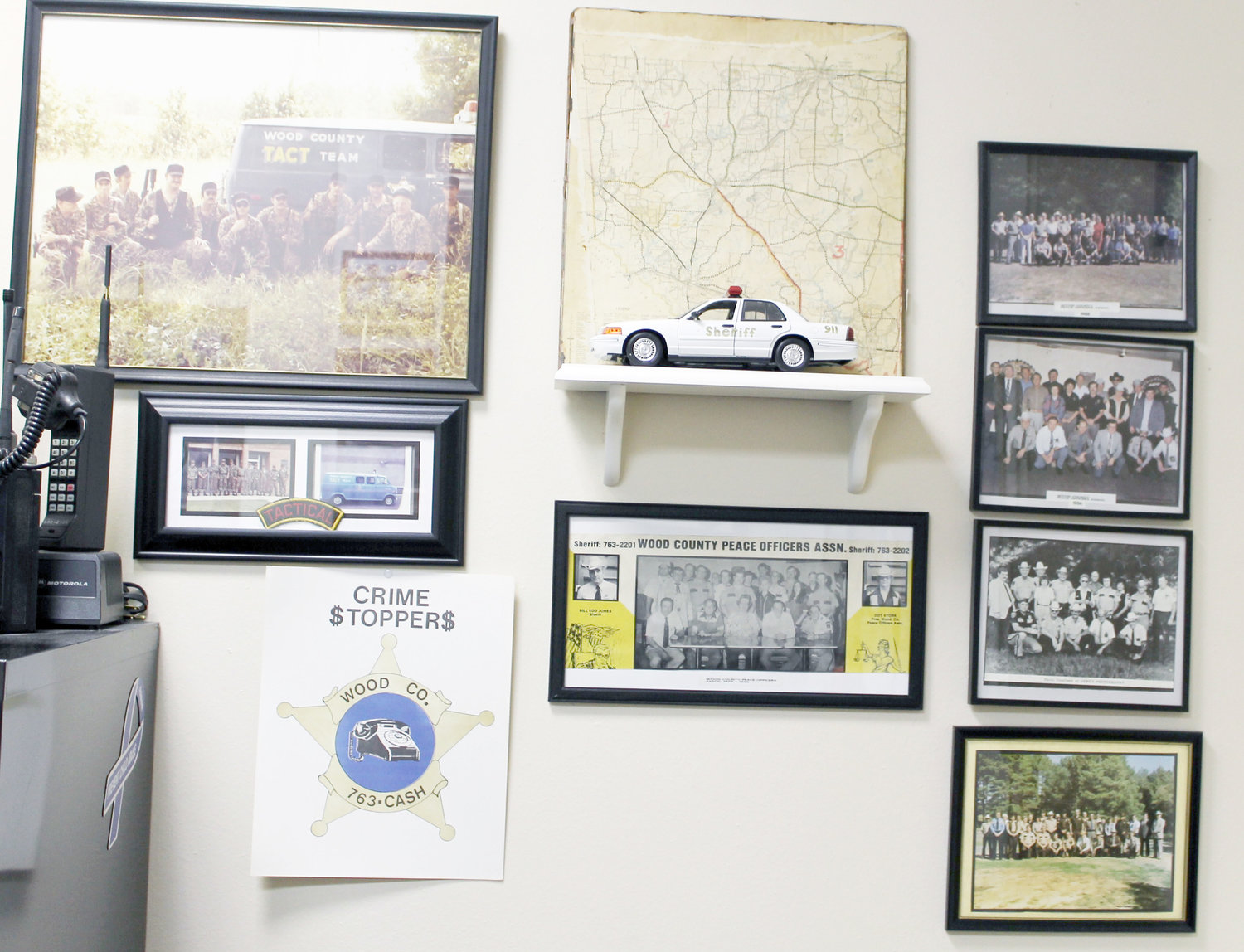The wall in Fox’s office bears evidence of the people who have come and gone over the 38 years she’s been there. Some of these group shots are from the old Wood County Peace Officers Association.