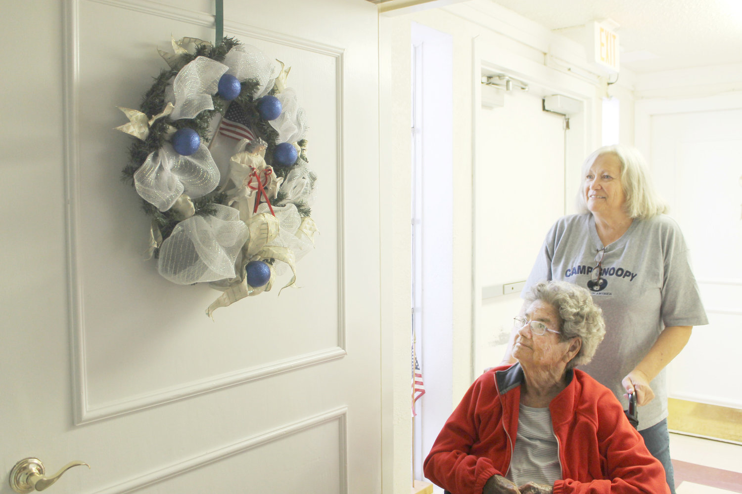Patterson gave Mary Winkle “a lift” to her room in her wheelchair where Winkle admires the wreath given to her by the Fannie Marchman Garden Club.