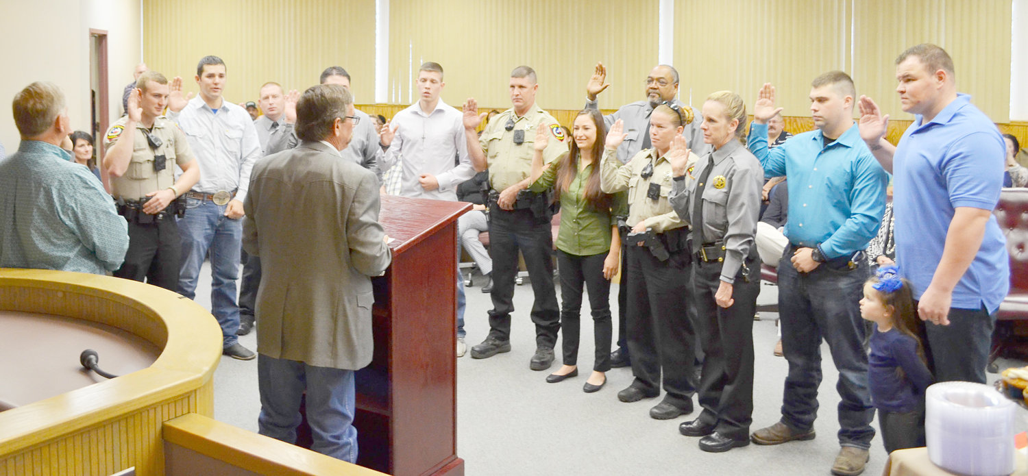 Members of the Wood County Sheriff’s Department are sworn in Sunday afternoon by newly-elected Sheriff Tom Castloo in the courtroom at the Wood County Justice Center, home to the sheriff’s office. (Monitor photo by Evan Dudley)