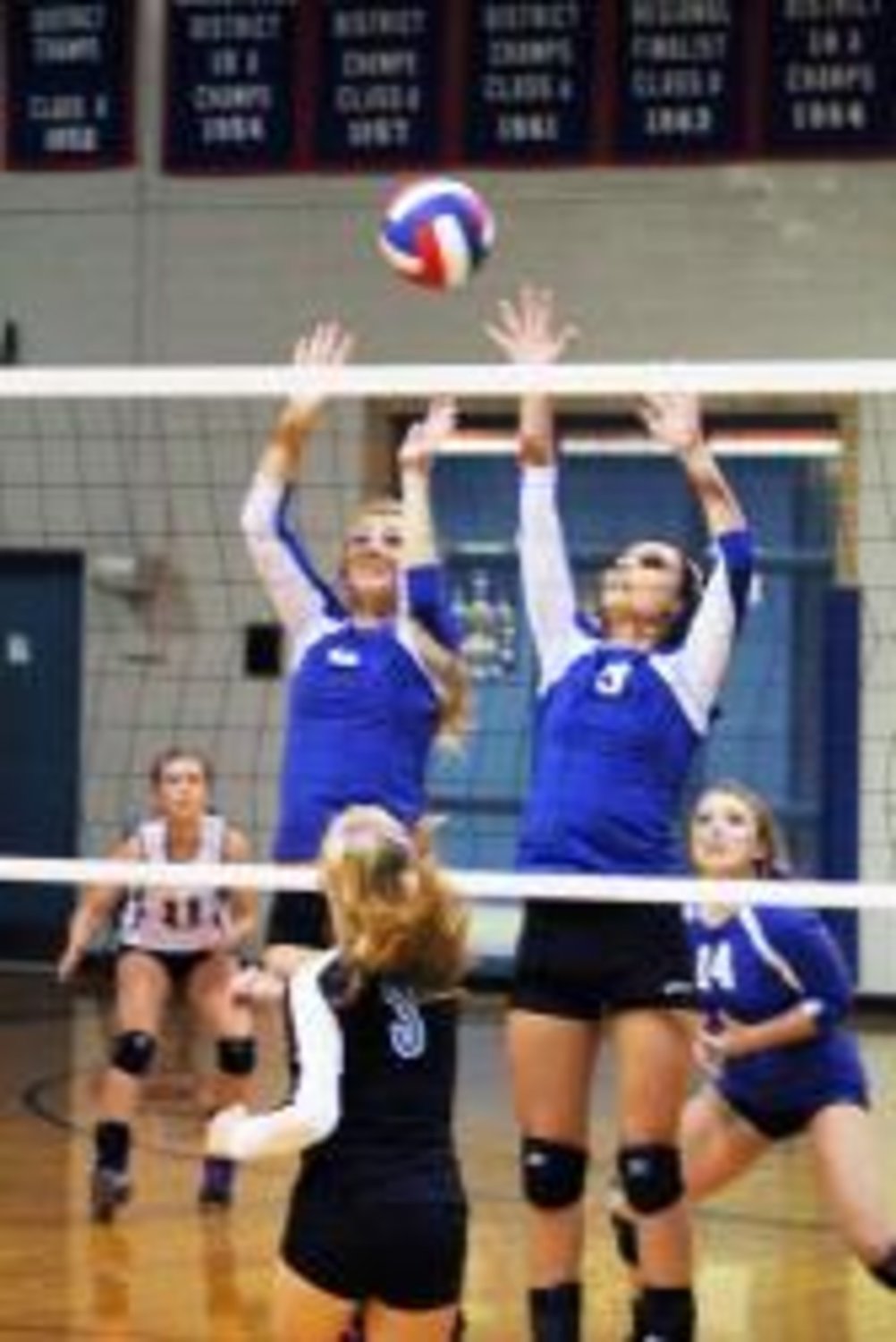 Seniors Shelby Herring (left) and Kelsey Daniel team up to block the kill as Alyssa Harris (11) and Beth Noble (14) get in position for a possible return in Friday's night victory against Commerce. The Lady Bulldogs remain undefeated with a 9-0 record in district play.