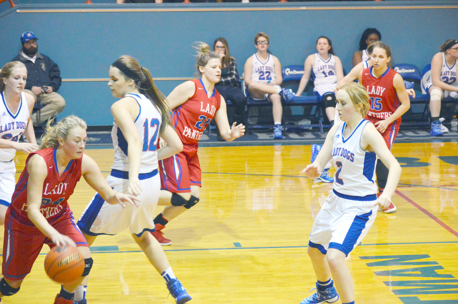 Alba-Golden’s Gracie Pendergrass (24) takes down a rebound and drives past Quitman’s Kaci Raley (12) as lady Bulldog Aubry Gilbreath (2) prepares to defend. Also in the photo are Lady Panthers Kenzie Chadwick (21) and Ashlyn Rogers (15). (Photo by Larry Tucker)