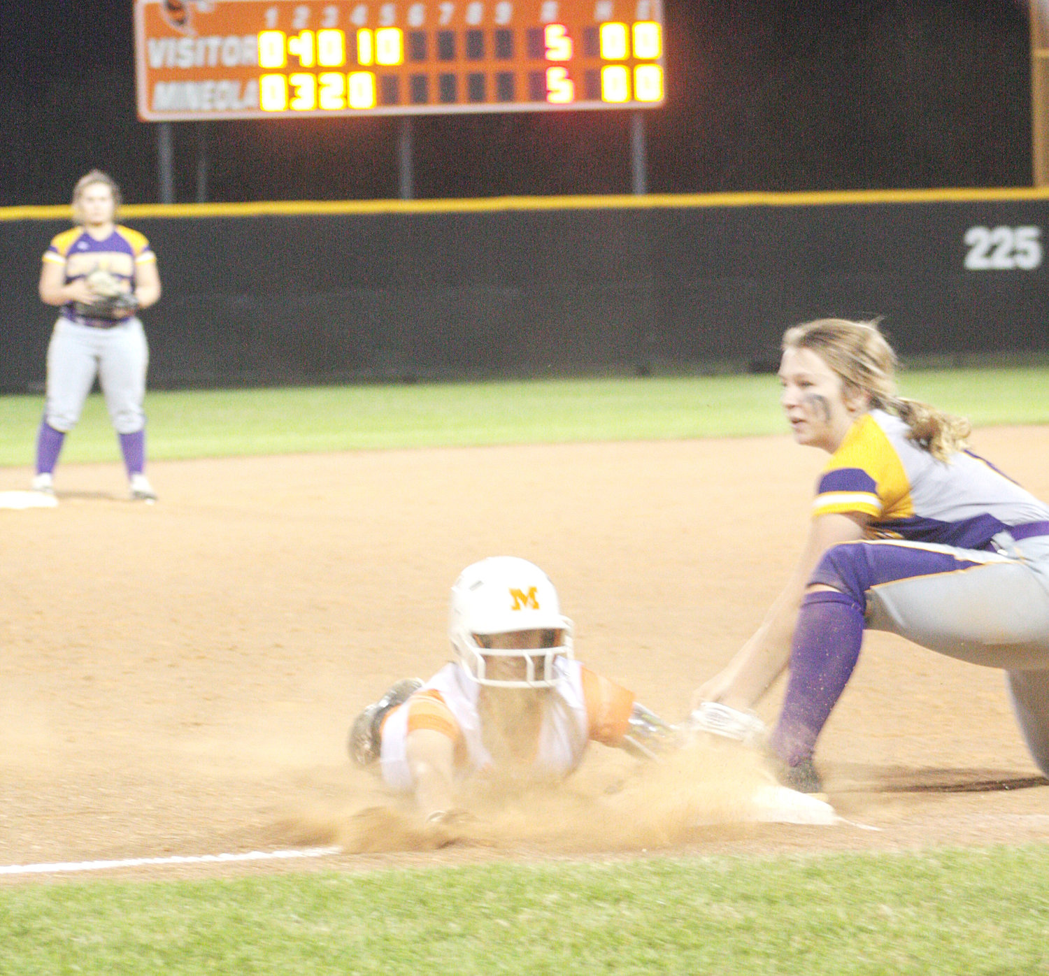 Abby Graves comes sliding head first in a cloud of dust to third base in the fifth inning Friday night in a District 12-3A game against Edgewood. Graves scored a short time later to put Mineola ahead to stay as the Lady Jackets defeated Edgewood, 8-7, in a crucial league game. (Monitor photo by Tommy Anderson)