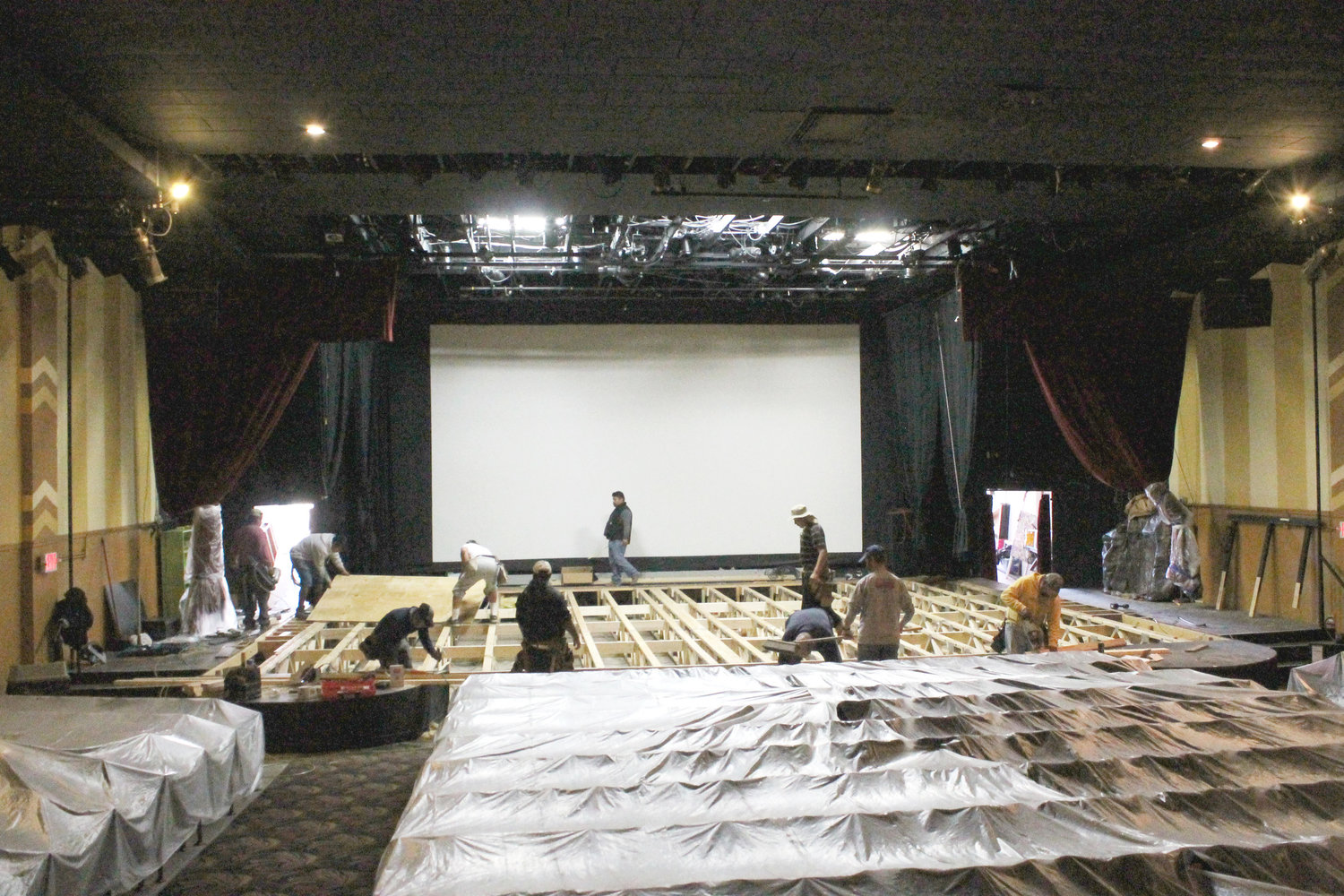 Skilled carpenters moved quickly Wednesday, removing the old stage at Select Theater and replacing it with a heavily-fortressed one, compliments the Mineola High School junior class and their donors. Around 2:30 that afternoon the first sheet of plywood was laid to begin the decking.