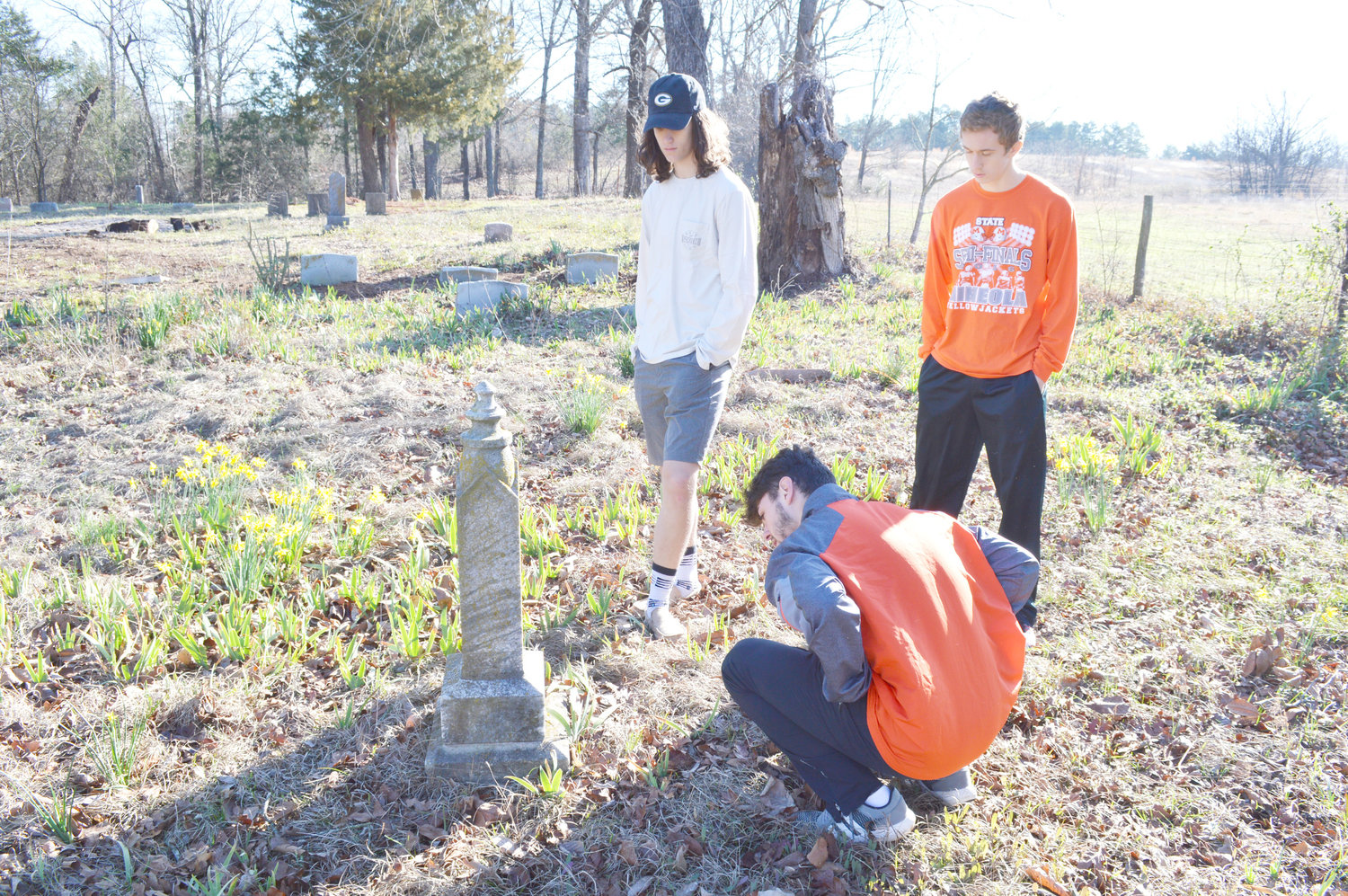 Juniors Austin Witt, Dalton Harris and Cameron Sorenson inspect tombstones at Rockfield Cemetery. After a clean up day and a military ceremony day, the three Junior Historians are pursuing Historic Texas Cemetery designation for the burial ground between New Hope and Hainesville. (Courtesy photo)