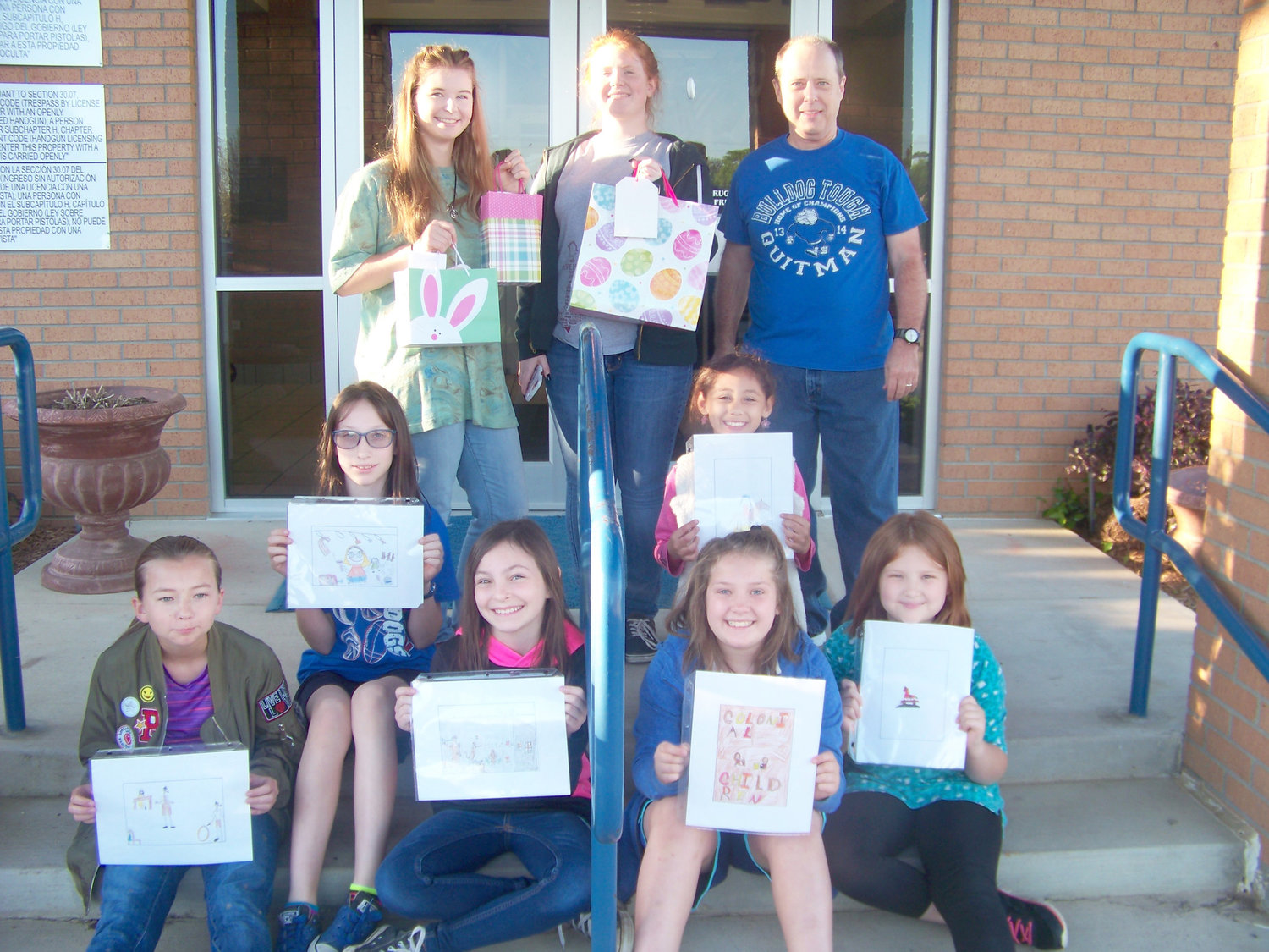 Quitman Elementary School students competed in a U. S. Postal Stamp Design contest sponsored by the Daughters of the American Colonists. Pictured are winners (front left to right) McKenna Burks, Peyton Kruckner, Alexandra Derryberry, Ariana Jarimello, Gabby Chaney, and Layla Shelton. In the back are members of the QHS Anchor Club who presented gifts. From left, they are Elizabethe Turner and Ashley Alexander. They are pictured with fourth grade social studies teacher, Kevin Clevenger.
