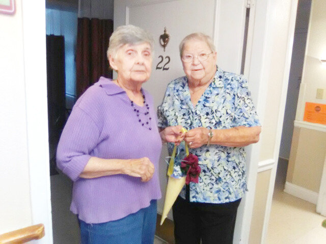 Betty Napier with the Mineola League of the Arts Quilt Guild presents Mineola Healthcare Residence resident Theresa Bonsal with a floral gift Thursday morning. The gifts were created by members of the quilt guild as a community service.