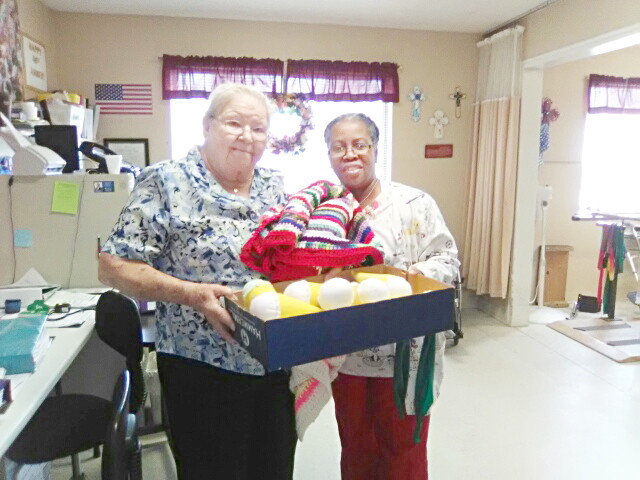 Betty Napier presents gifts to Feleta Stewart, rehabilitation director, at Wood Memorial Nursing home. Shown in the box are homemade, felt ice cream cones which can be used to practice gripping.