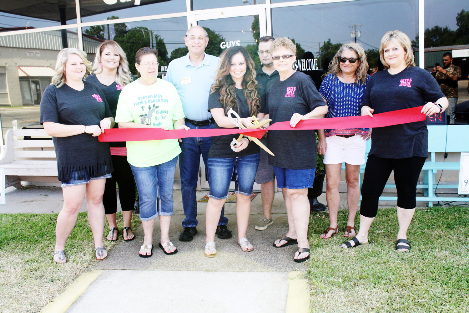 Amber Gaby, owner of Guys and Dolls on the square in Alba, cuts the ribbon celebrating the Grand Opening of the salon.