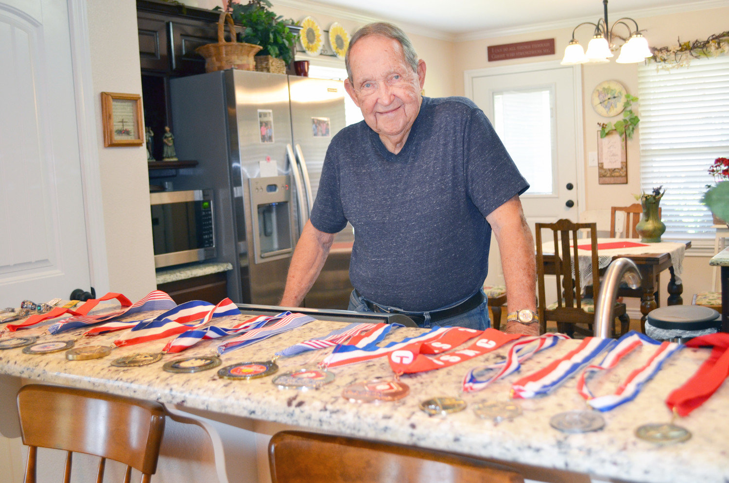 Bill Blakemore and his array of tournament medals won by senior softball teams on which he played.