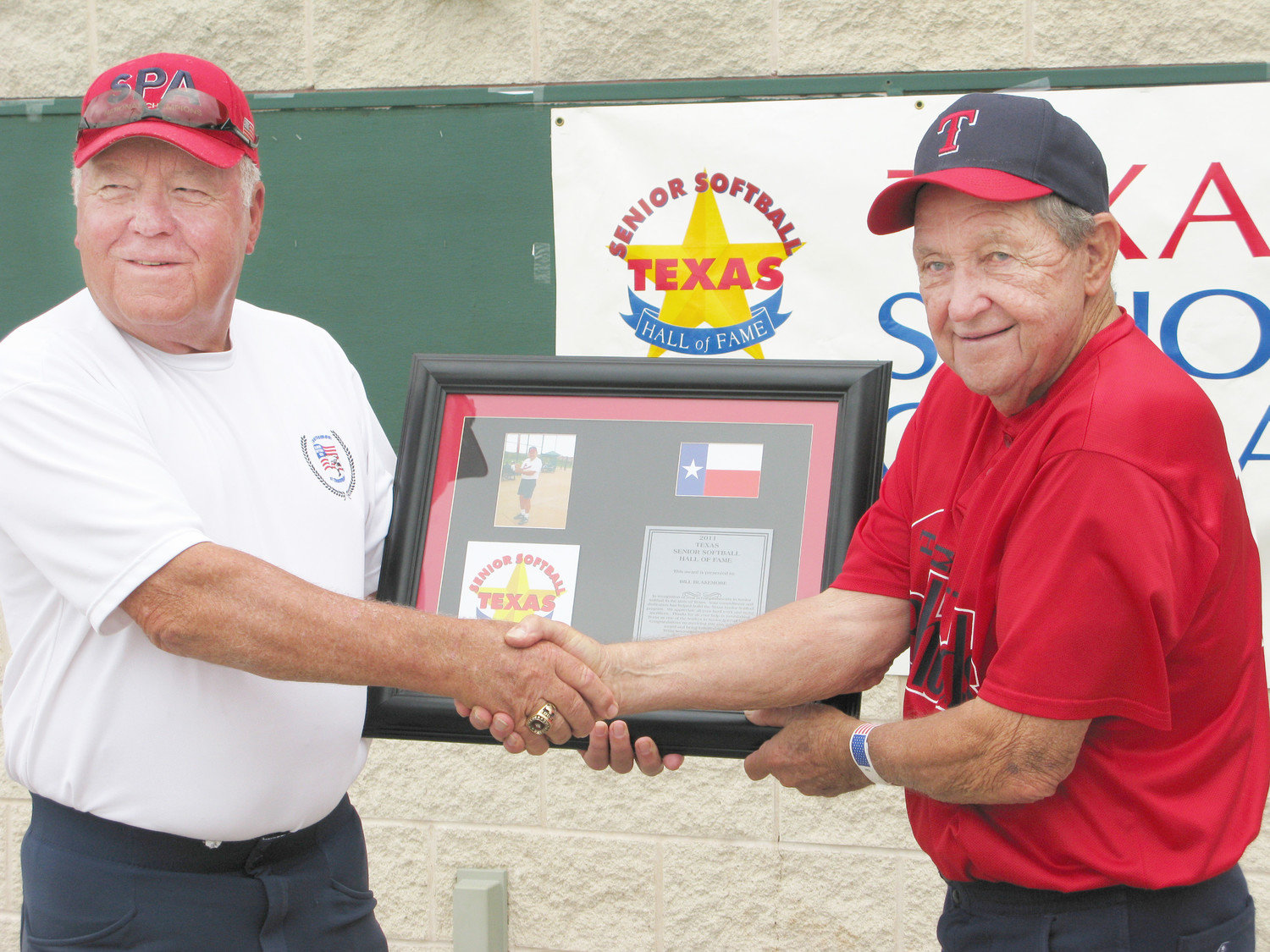 Bill Blakemore receives a plaque from Jon Bryan, an official with the National Senior Softball Players Association, during his induction into the Texas Senior Softball Hall of Fame in 2011.