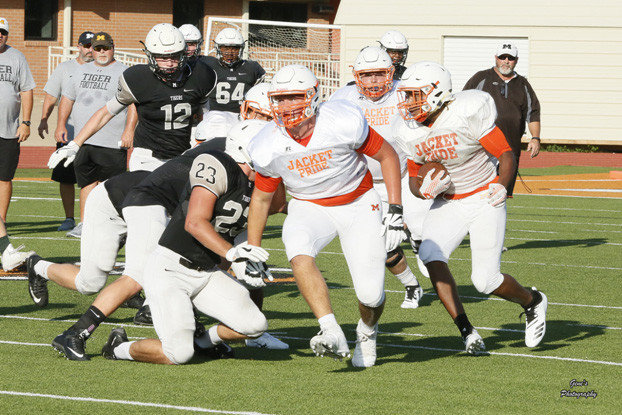 Jackson Anderson clears the way for a Mineola running back in last week’s scrimmage against Malakoff.