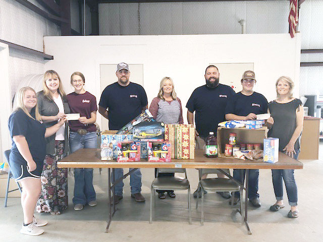 A donation of $1,000 was made by the Quitman Young Farmers and Quitman FFA recently to Christmas Sharing and Caring Plus at their facility. Pictured here are (left to right) Brenley von Reyn (Quitman FFA), Michelle Dobbs (Quitman Sharing and Caring Plus), Jentri Jackson (Quitman FFA), Corey Hammond (instructor), Gena von Reyn (Quitman Young  Farmers), Brant Lee (instructor), Marcus Pollard (Quitman FFA), and Rita Johns (Quitman Food Pantry).