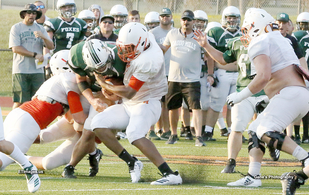Mineola defenders stop a Caddo Mills running back at the line of scrimmage.
