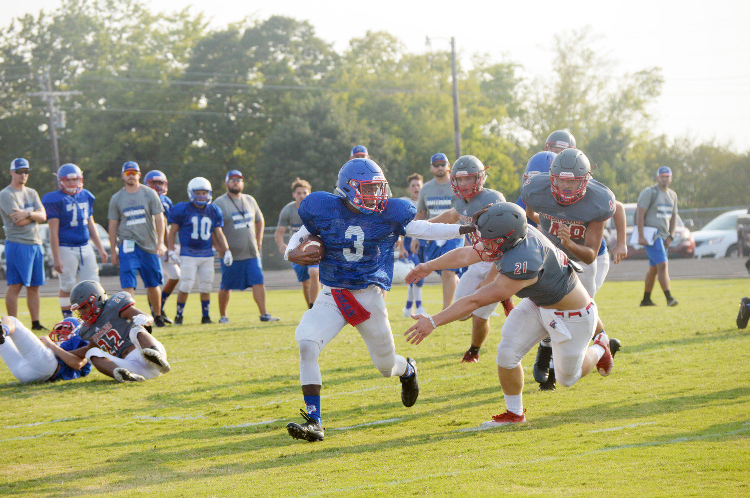 Quitman’s Trey Berry (3) stiff arms a Paris Chisum defender on the way to a 65-yard scoring touchdown in the Bulldogs scrimmage last Thursday.