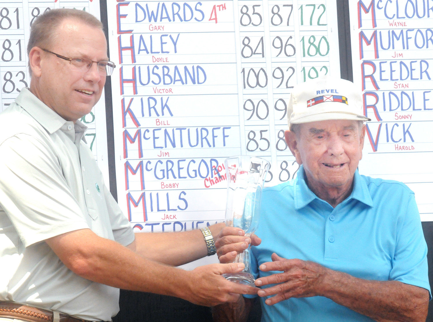 Holly Lake Golf Pro Jeff Wilson hands Super Senior Champion Bobby McGregor his trophy. McGregor shot two consecutive rounds below his age to capture the title.