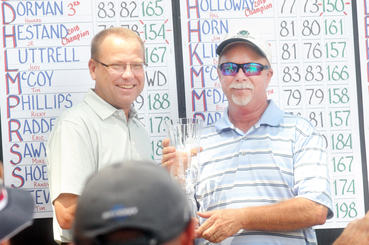 Holly Lake’s Jeff Wilson presents Club Champion J. R. Hestand his trophy after Hestand won his third club championship with rounds of 76 and 78 for a two-day-total of 154.