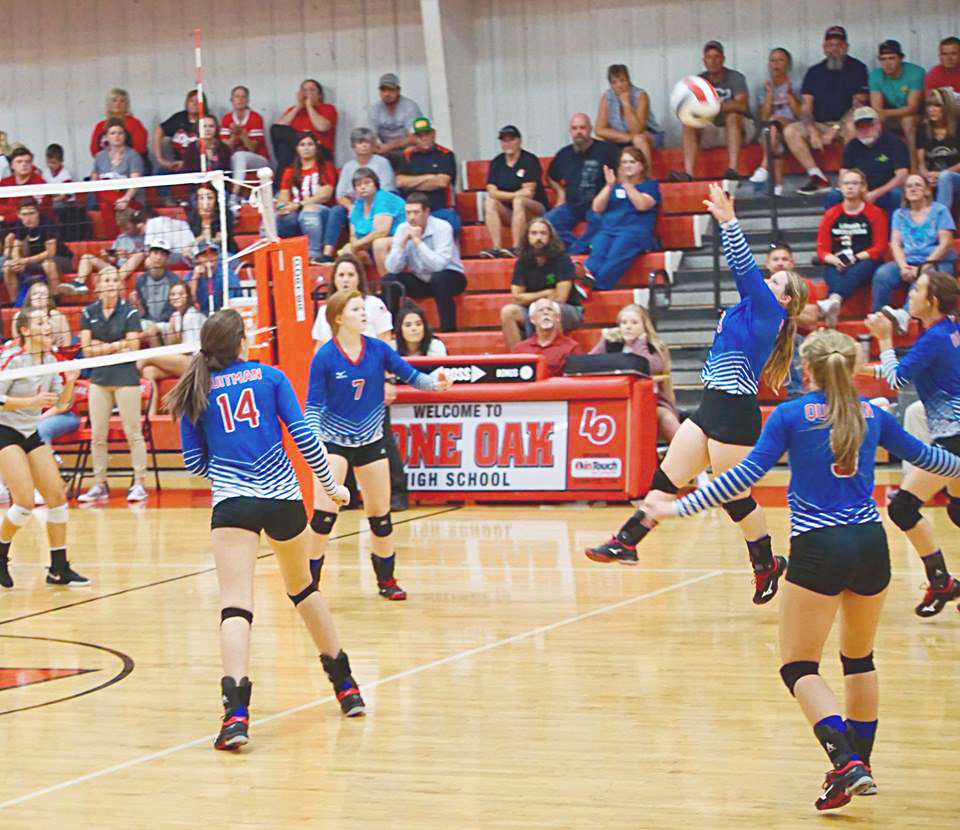 Abby Dobbs (9) sets a pass as Shelby Hayes (7) and Ava Burroughs (14) get ready to receive.