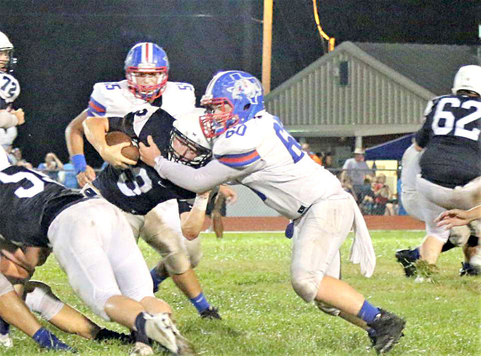 Quitman’s Hunter Gilbreath (60) stops Union Grove quarterback Mike Webb (3) in Friday’s 28-22 overtime loss.