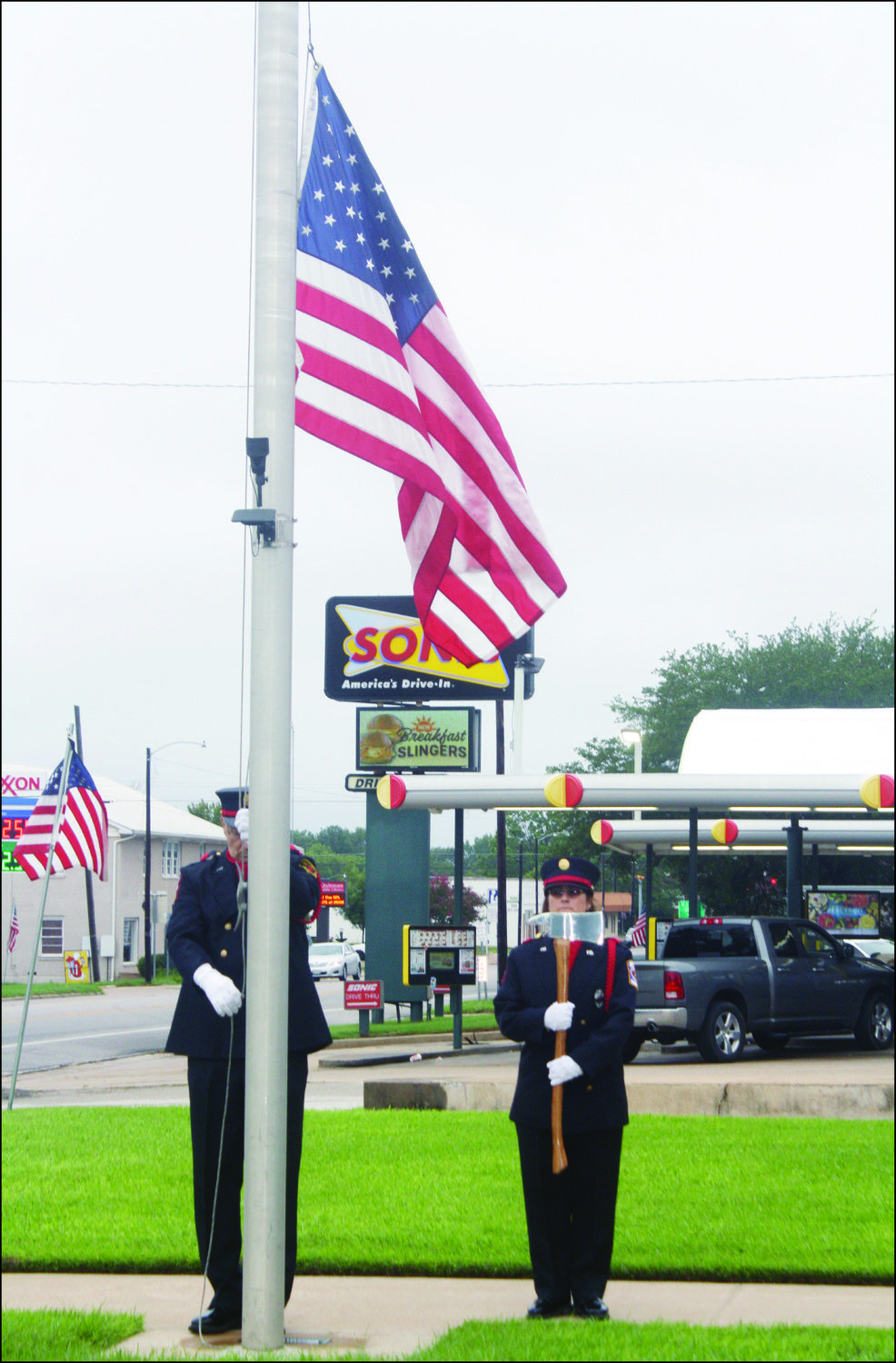 Tammy Gilmore of the Quitman Volunteer Fire Department and Bill Bollinger of Holly Lake Ranch Volunteer Fire Department lower the American flag to half-mast outside Quitman City Hall and Fire Department for the 9/11 memorial ceremony  on Sept. 11. Gilmore and Bollinger are both members of the Wood County Honor Guard.