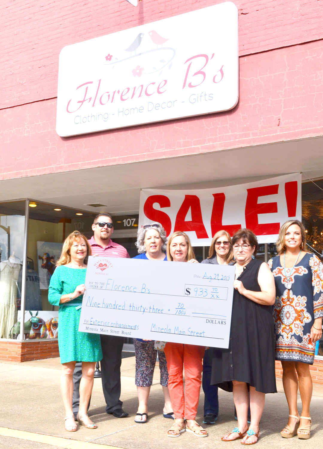Main Street Director Doris Newman, left, presents a check for $933 to Florence B’s Owner Theresa Ward. At right is Main Street Board Director Wanda Dubbs. Back row from left are directors Nic Watkins, Pat Hamlett, Allison Utley and Misty Hooks. Florence B’s, used its grant for new signs at its Johnson Street location.