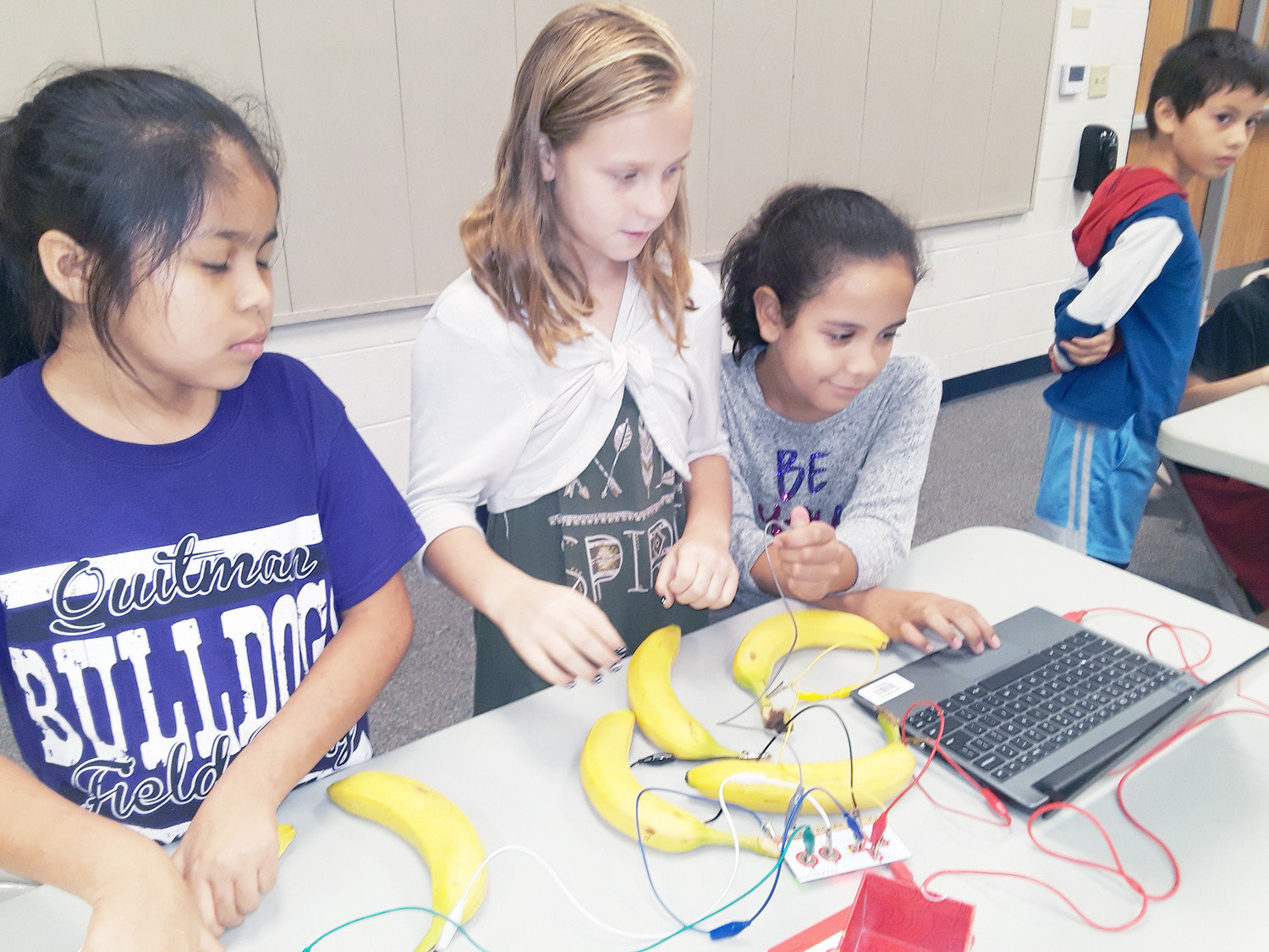 From left to right: Natalie Flores, Kelsey Oakes, Vanessa Saucedo, Rolando Molina work with the “Makey Makey” project in their robotics lab on Sept. 21 for Fab Friday. They divert the electricity to the bananas to see how electricity in machines work. (Monitor photo by Zak Wellerman)