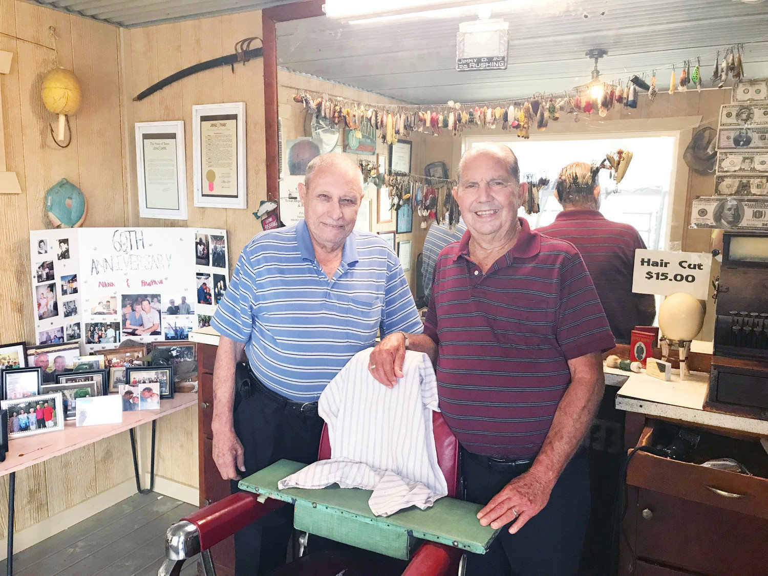 Jimmy Rushing, right, and longtime friend Jerry Rapp stand inside the new Broadway Barber Shop exhibit behind the Mineola Historical Museum. Rushing, who retired earlier this year, donated the contents of his barber shop to the museum. The exhibit replicates Rushing’s shop, which he opened in 1961, when he sold haircuts for 50 cents. It features an antique Belmont barber chair, old barbering equipment, walls full of memorabilia, an antique cash register, an old-time fishing lure collection, a shoe shine station, and many other items of historical note. The exhibit was formally opened with a ribbon-cutting and an open house at the museum on Saturday, Sept. 22. (Monitor photo by Hank Murphy).