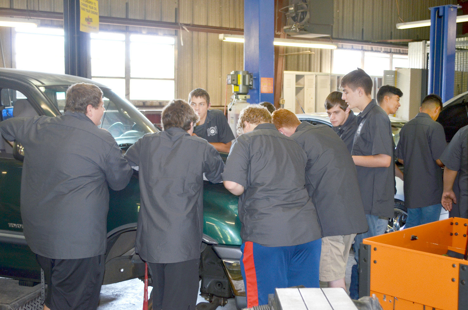 Mineola High Auto Tech students prepare to lift an engine. (Monitor photo by Hank Murphy).