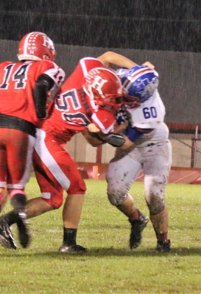 Quitman’s Hunter Gilbreath battles with a Harmony lineman in Friday’s district contest played in the rain at Harmony. (Photo by Sheree Phillips)