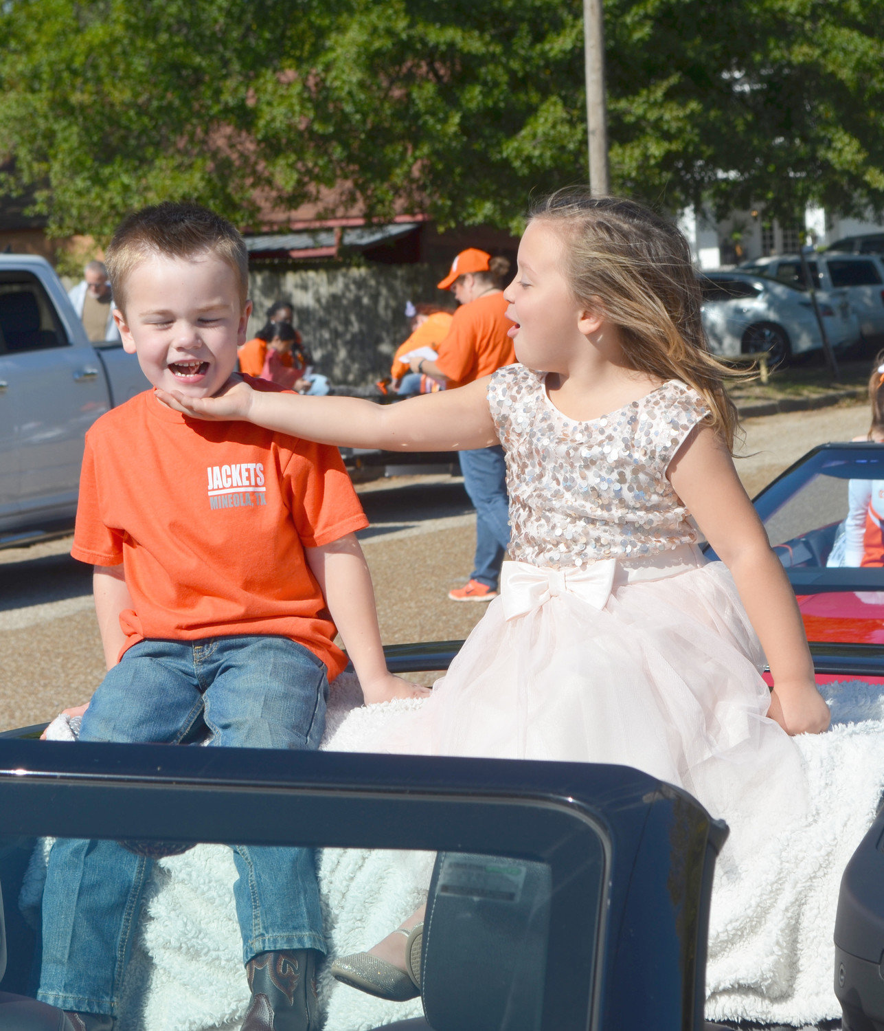 Crown of Flower Bearers Olivia Hogue and Colt Turner share a light moment before the start of Friday’s Mineola High School Homecoming Parade.