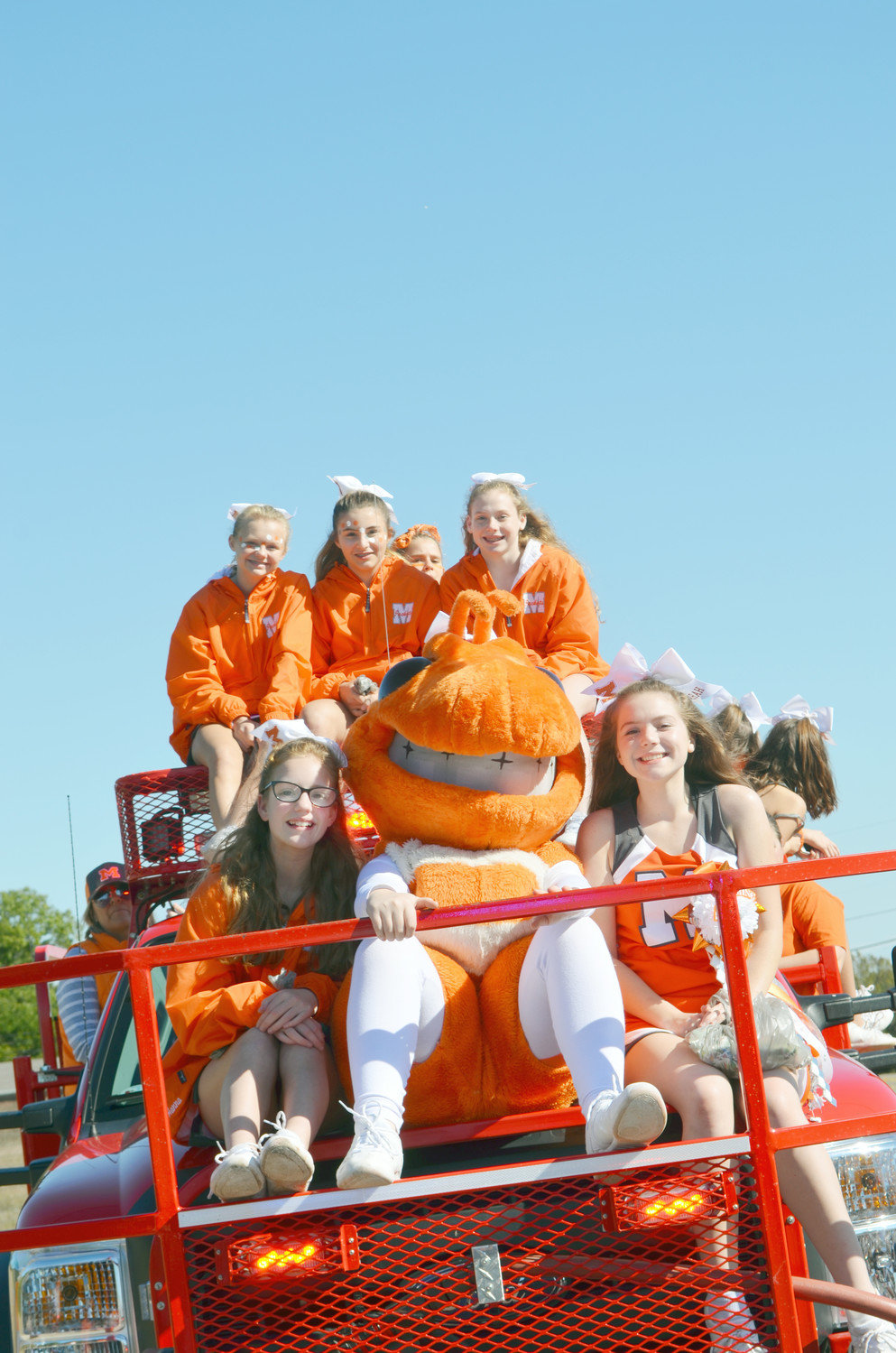he Yellowjacket mascot is surrounded by a host of young supporters of Mineola High School during the Homecoming Parade on Friday along Broad Street.