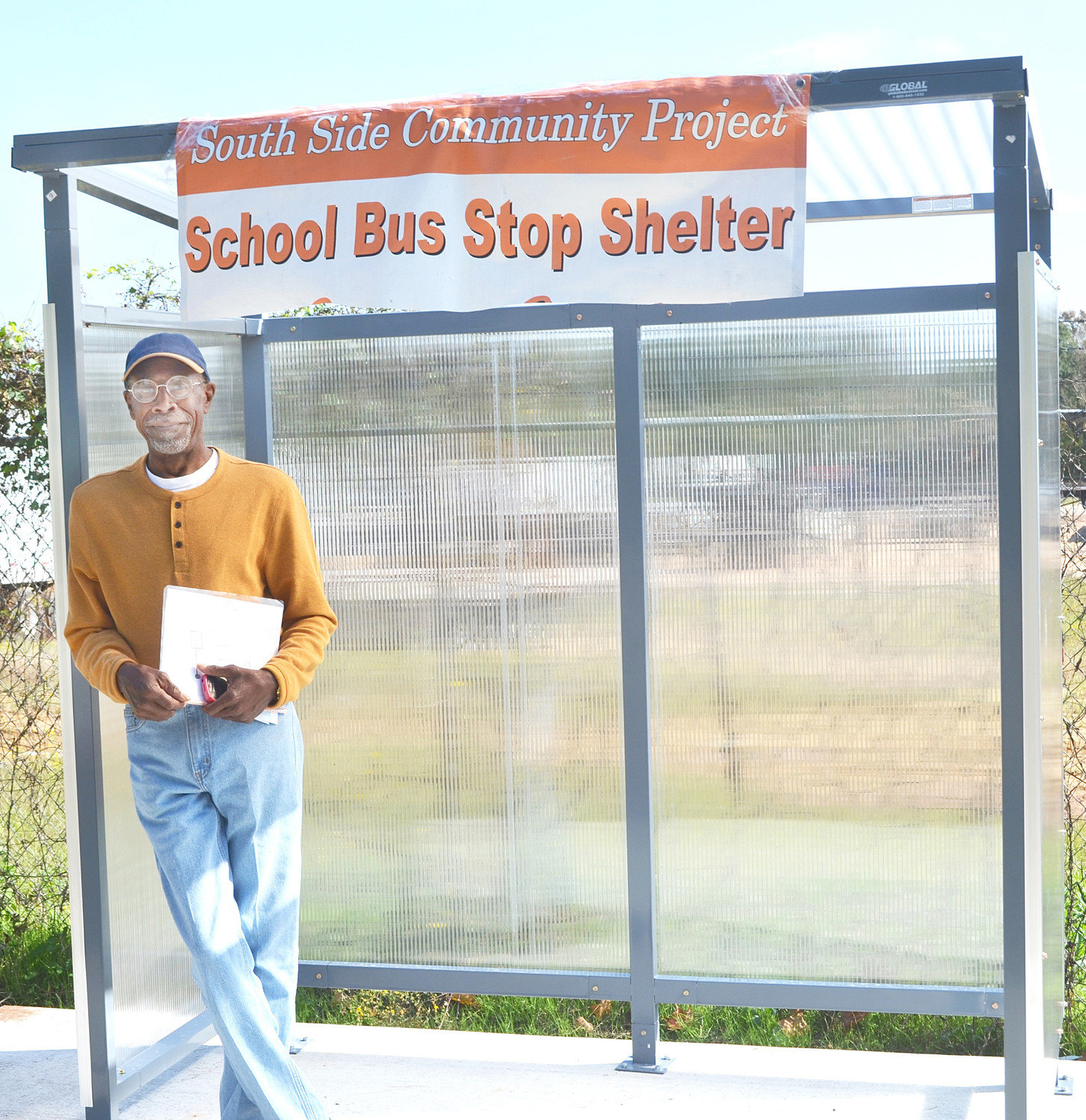 Gerald Russell stands at the new school bus stop shelter on Baker Street.
