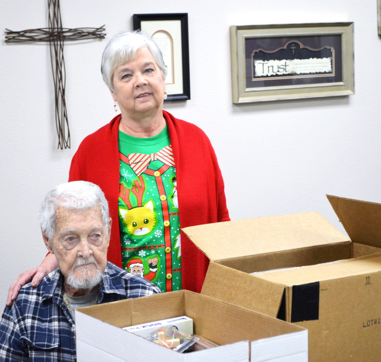 Ellen Jackson and her father, Neil Harle, at Saturday’s packing event at First United Methodist Church’s Ministries Center. The church is sending about 50 boxes filled with various treats to American troops in Afghanistan. (Monitor photo by Hank Murphy).