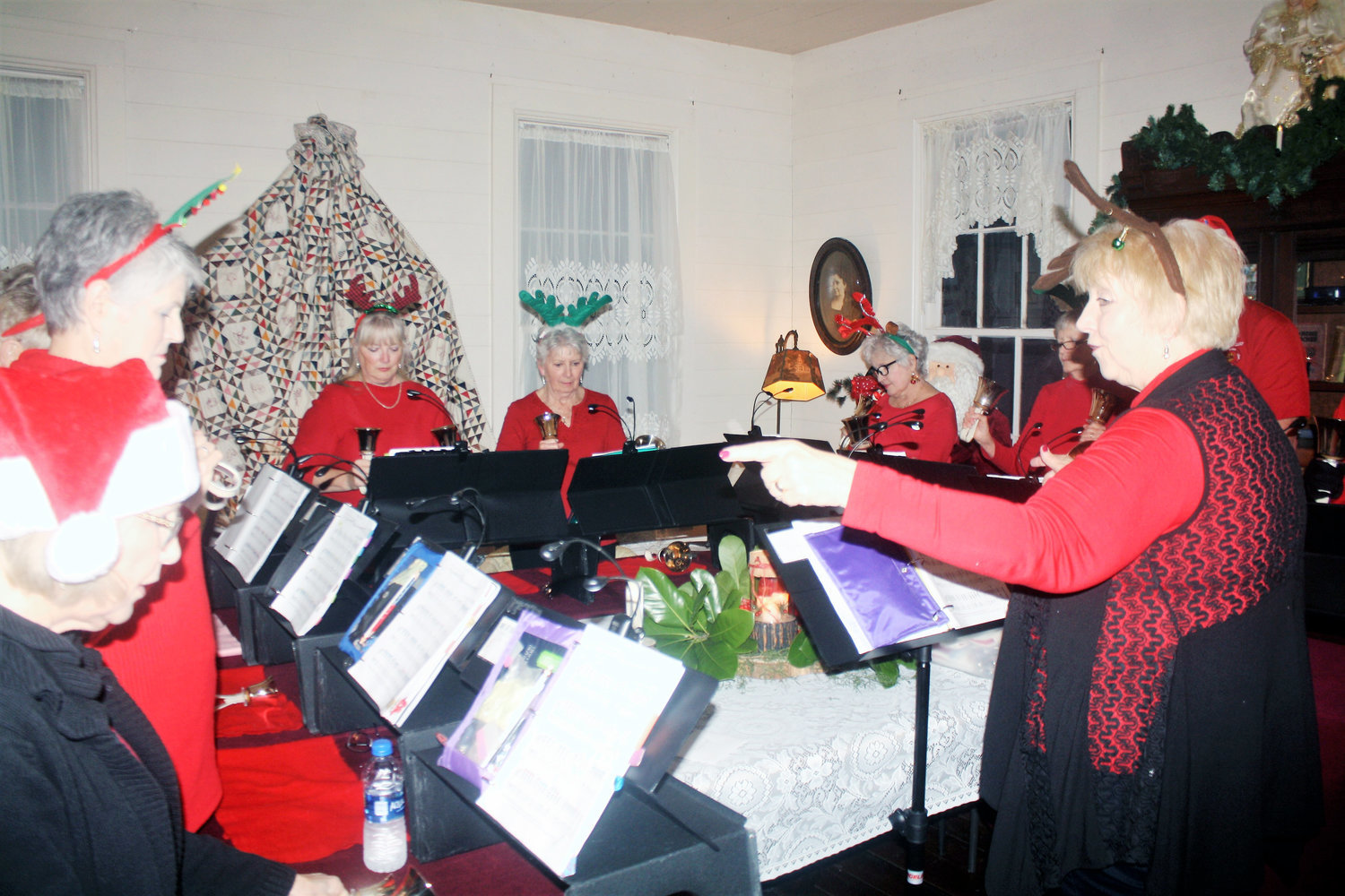 Liberty Bells of the Liberty United Methodist Church perform at the Stinson House holiday open house on Dec. 13. The event featured treats, live music and cheerful holiday decorations.