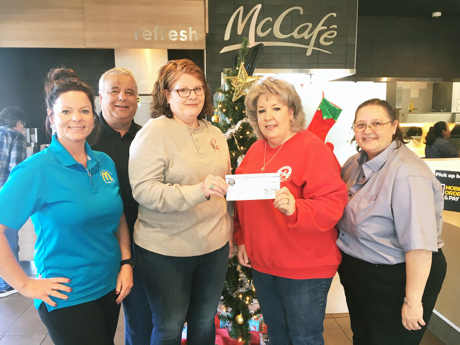 Bernadine Corley, center left, accepts a $200 check from Mineola Main Street Board Secretary Pat Hamlett. Corley was the week four winner in the Shop Local campaign to promote Mineola businesses, and her winning receipt was for a purchase made at McDonald’s. McDonald’s owner Kevin Lilly of Athens; public relations person Berta Winn, far left, and manager Tina Kneitz were present for the occasion.