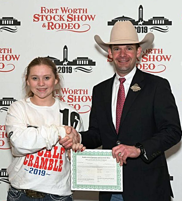 Carlee Vavra of Yantis FFA is presented her calf scramble certificate at the Fort Worth Stock Show and Rodeo.