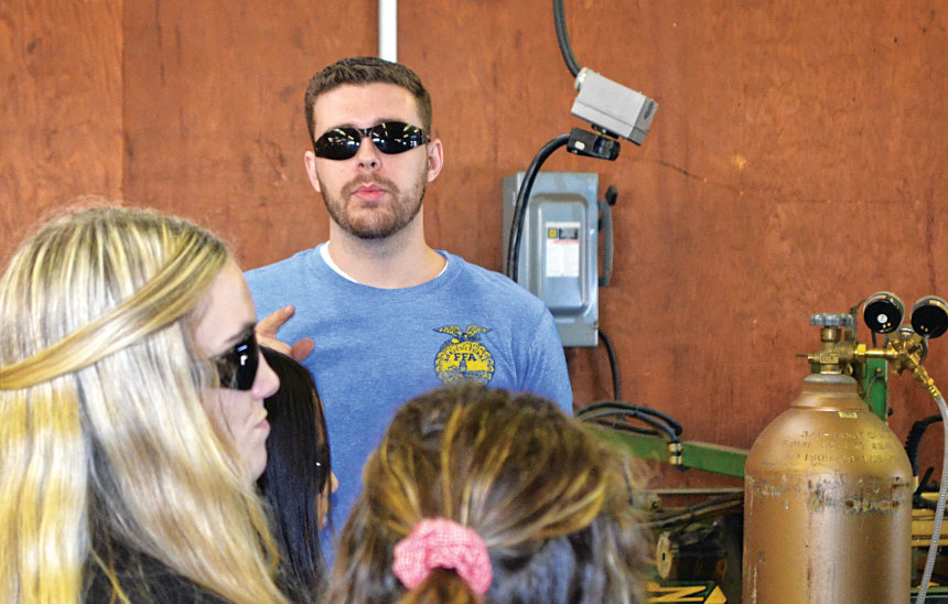 Welding instructor Brandon Williamson dispenses information about the high school welding program to eighth-graders, who were visiting the high school as part of Career Day last month.