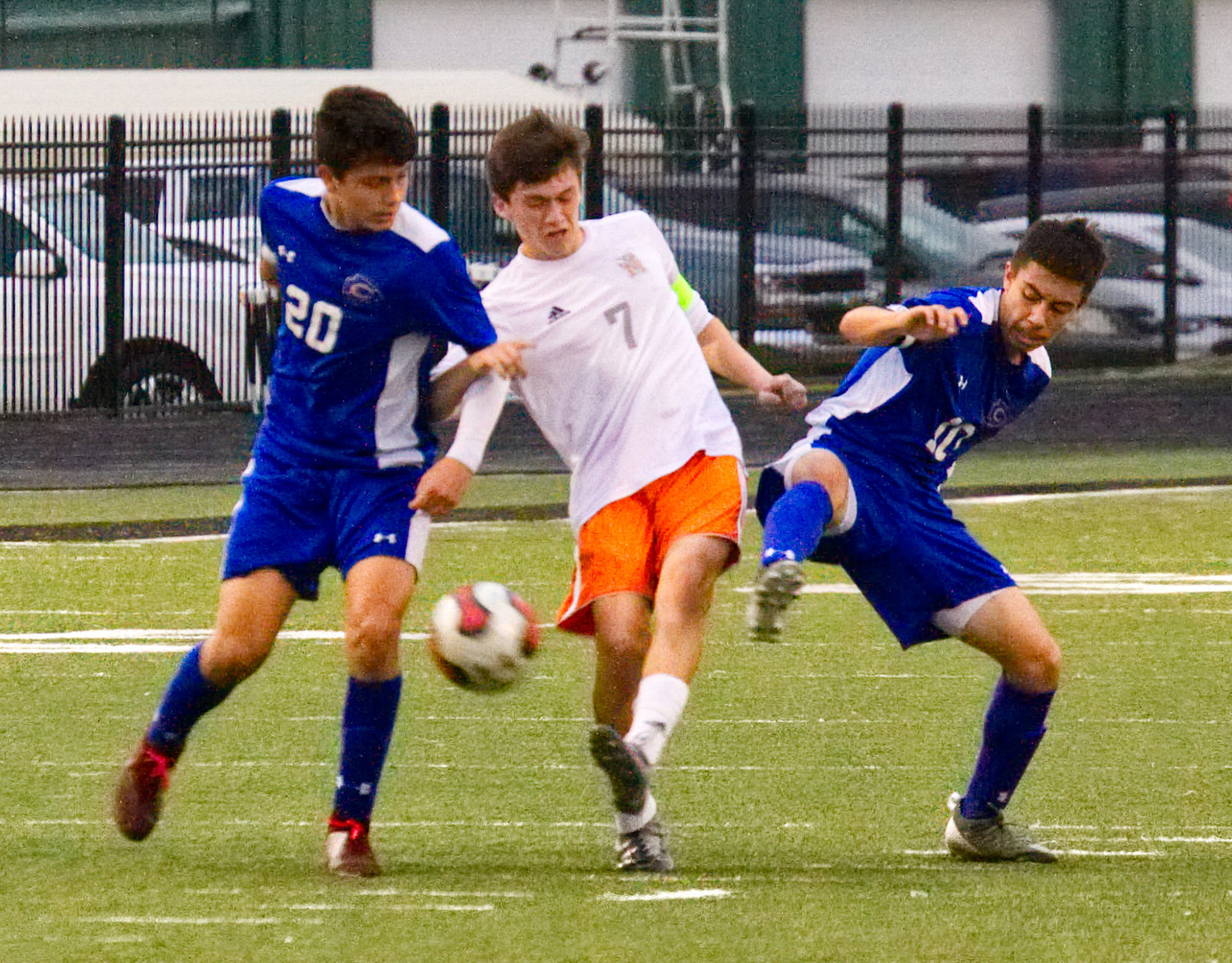 Yellowjacket Liberio Perez fights through two Community Brave defenders in the midfield.
