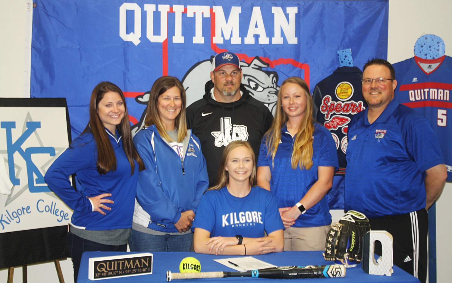 Quitman senior Madalyn Spears is surrounded by her coaches after she signed to play softball at Kilgore College. Spears has been involved in softball, volleyball, track and basketball. Coaches pictured from left to right are head volleyball coach, head girls track coach and girls coordinator Ashlee Lingo, assistant volleyball and assistant softball coach Elizabeth Miller, QISD Athletic Director Bryan Oakes, junior high volleyball and assistant basketball coach Allison McKinley and softball coach Chris Veach.