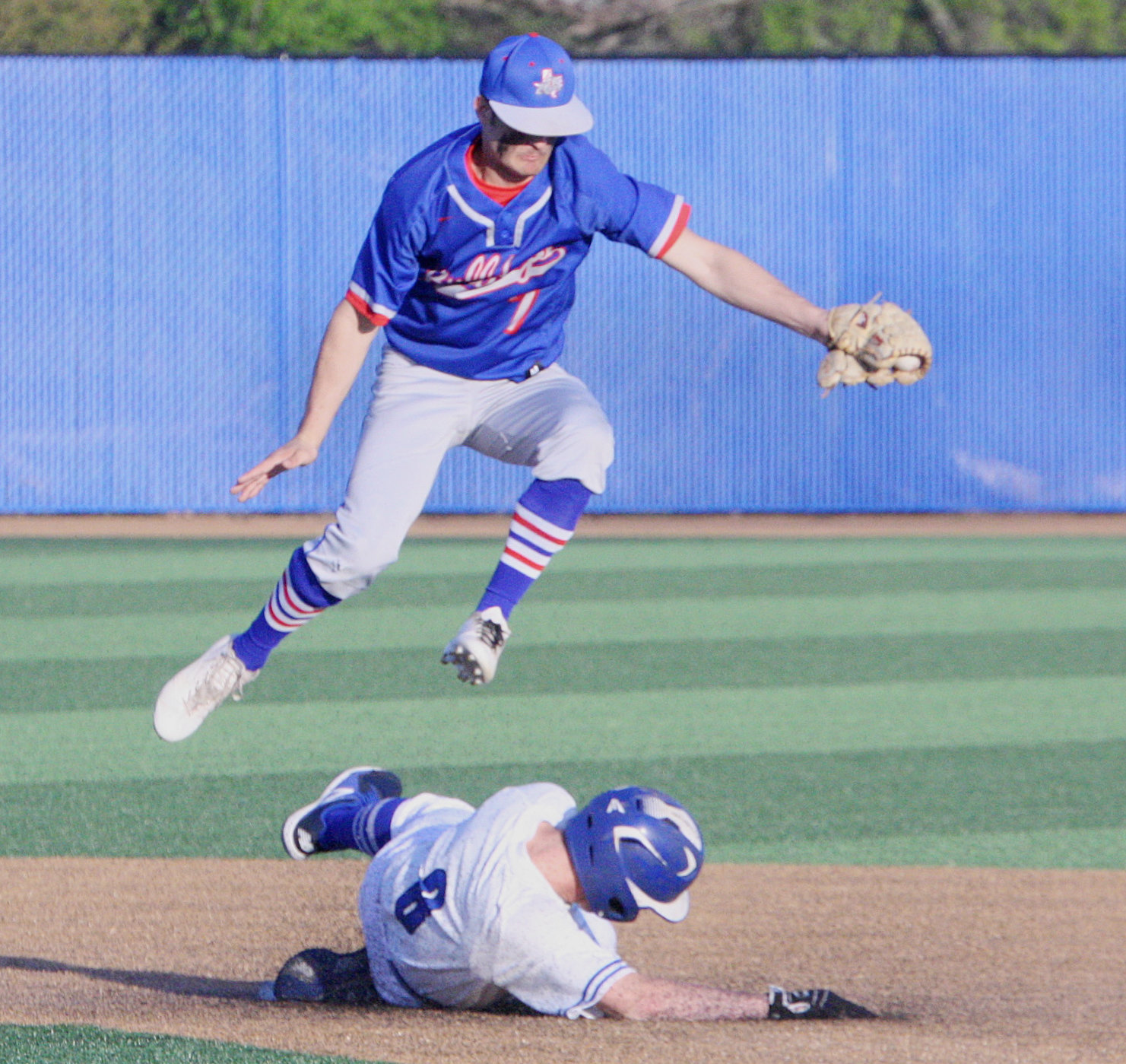 Quitman’s Ty Holland goes up to field catcher Trey Berry’s throw at second base.