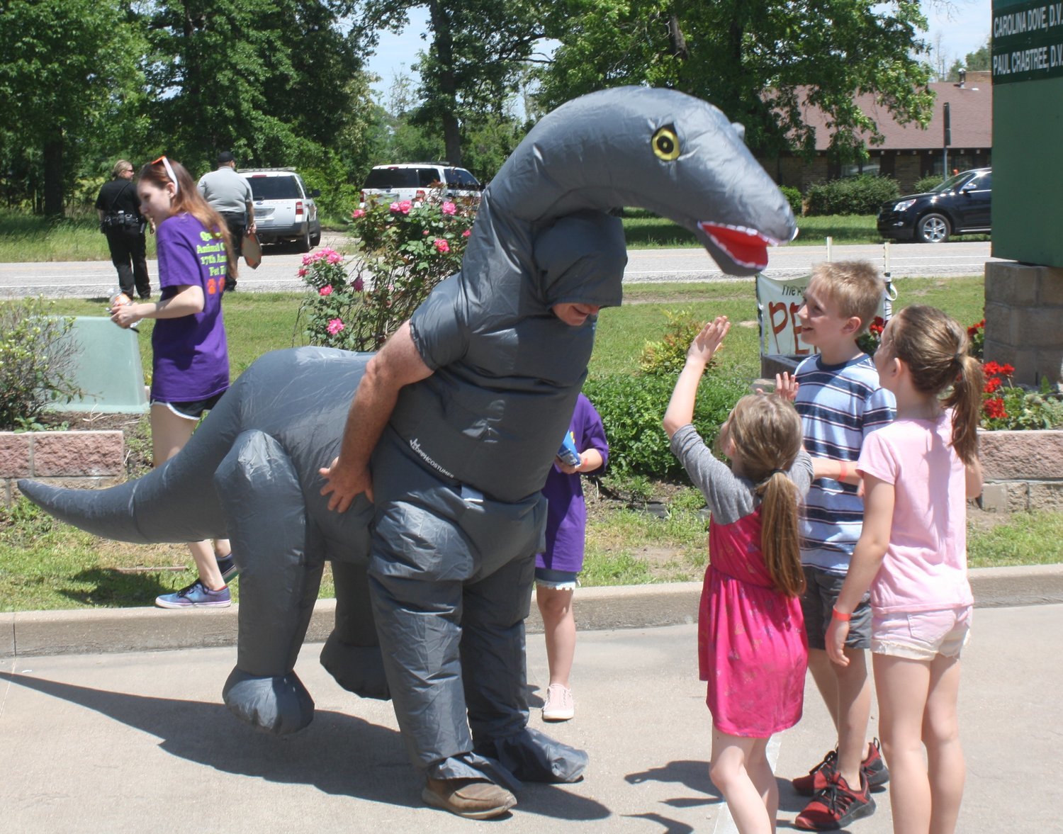 Quitman Animal Clinic owner Dr. Randy Bennett, dressed as a dinosaur, greets children attending the QAC 17th annual Pet Fair on Saturday, April 27. The fair had a large turnout with many activities and games for all ages.