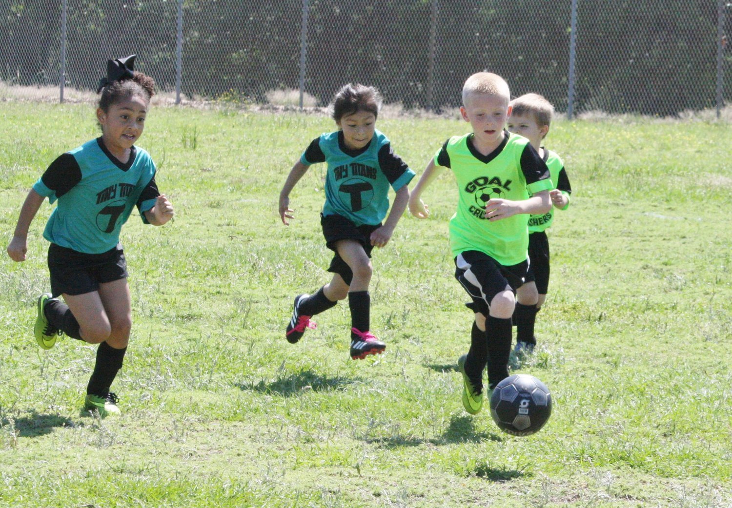 Local youths in hot pursuit of the soccer ball during a Saturday morning game of the Mineola Soccer Association.