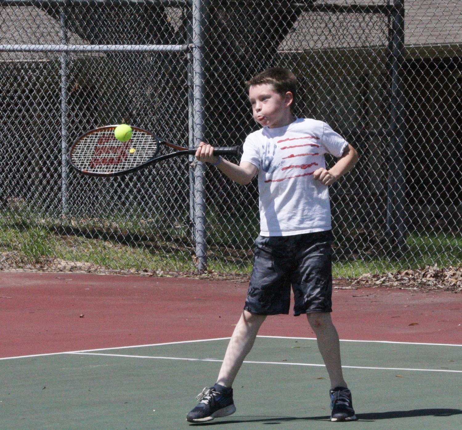 A youngster takes advantage of the great tennis courts available at the Mineola Civic Center grounds.