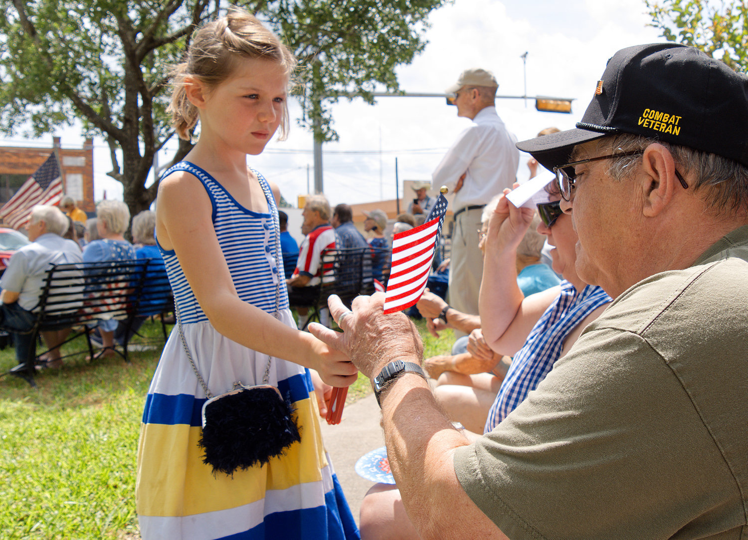 A youngster passes out American flags at the Memorial Day ceremony held on the Wood County courthouse grounds Monday morning.