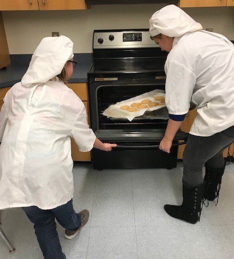 Quitman High School culinary arts students take one of their cooking projects out of the oven.