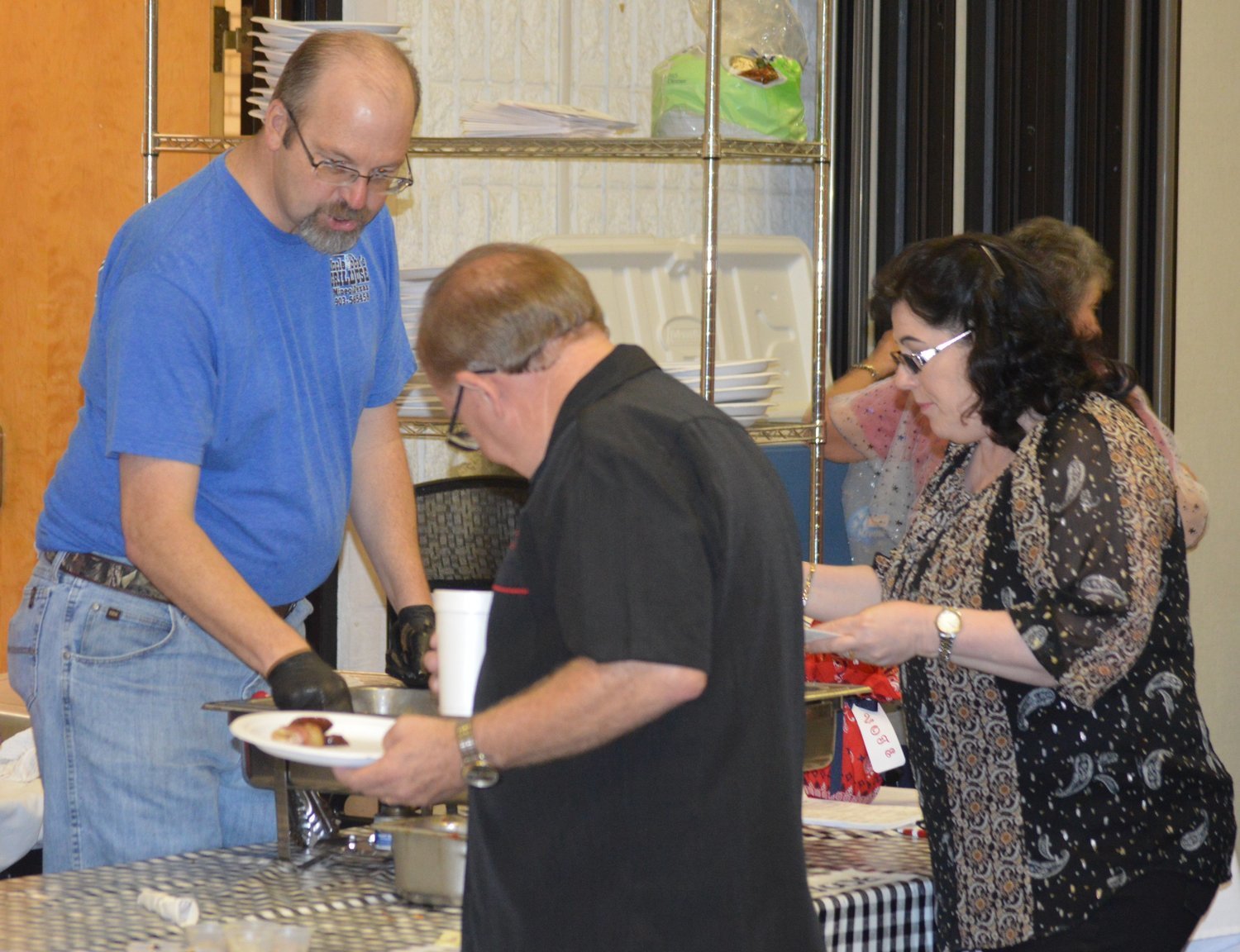 Brad Cobern, owner of Uncle Bubba’s Grillhouse in Mineola, serves food to guests at the 20th Annual Taste of East Texas event on Saturday night at the Mineola Civic Center.