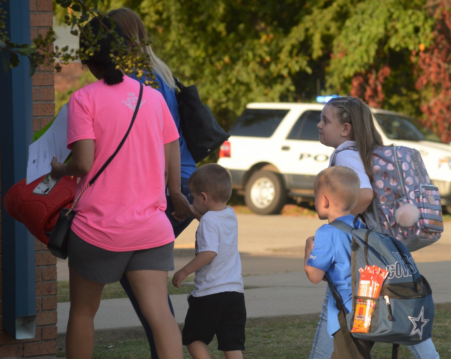 Quitman Elementary students along with their guardians walk toward the QES school entrance during the first day of school on Aug. 21.